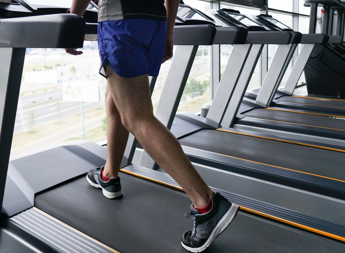 A man looking confused and slightly pained while using a treadmill, seemingly overwhelmed by the settings and options.