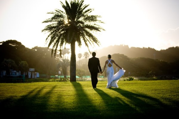 A photograph, presumably from a destination wedding, featuring a couple in a pose that suggests either intense romance or impending leg cramps.