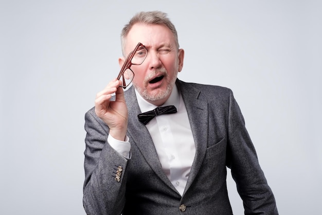 Premium Photo | Senior man looking through his glasses trying to see