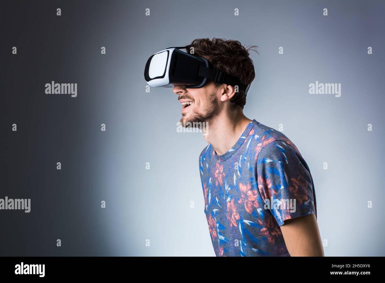 A young man deeply immersed in a virtual reality experience, showcasing a range of emotions.